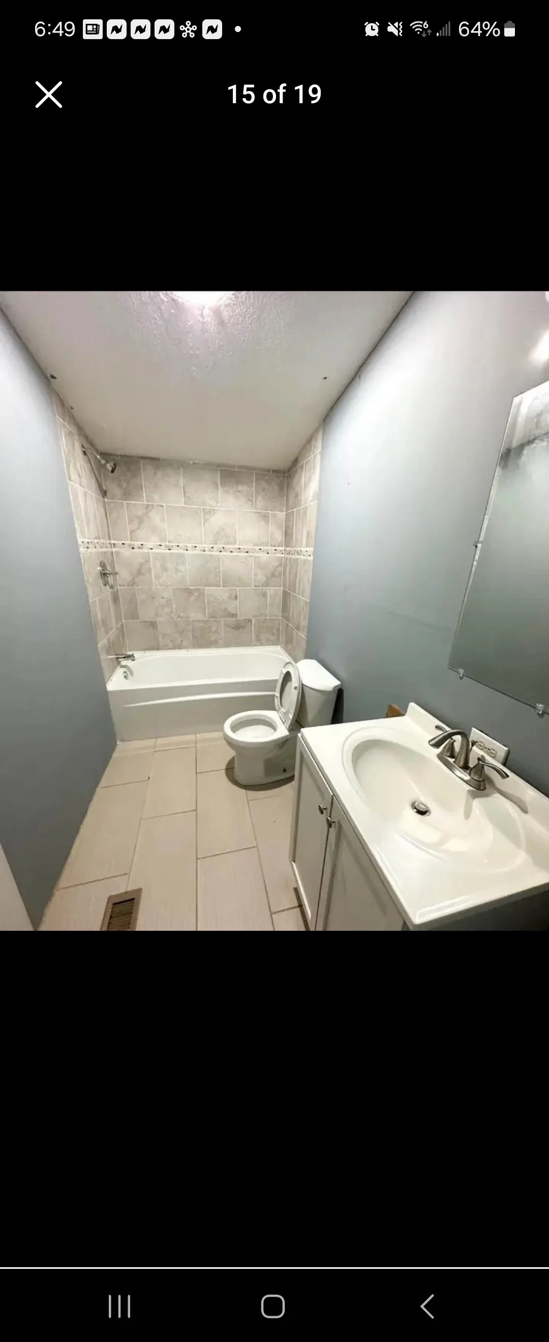 Renovated bathroom with new tile flooring, wall tile, white fixtures, and fresh paint
